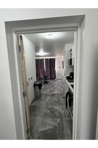 a hallway of a room with a kitchen and a door at Home Sweet Home in Dagenham Dock
