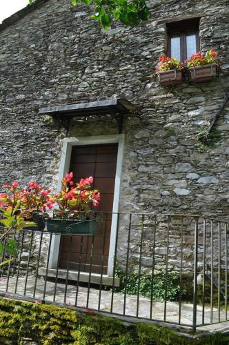 a window of a stone building with flowers on it at Borgo Isola Santa in Isola Santa