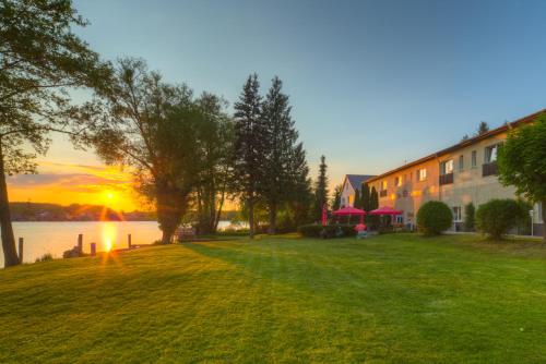 a house on a lawn with the sunset in the background at Alte Schlossbrauerei in Mirow