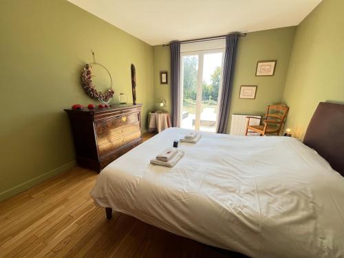 a bedroom with a large white bed and a window at Les hauts de Merfy maison 5 chambres avec piscine 