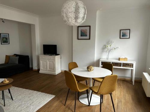 a living room with a white table and chairs at Appartement de centre in La Louvière