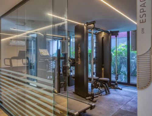 Un gimnasio con paredes de cristal y máquinas de correr. en Alta Marine flat 304, en João Pessoa