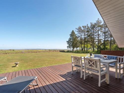 a patio with a table and chairs on a deck at Holiday Home Saila - 500m to the fjord by Interhome in Blåvand