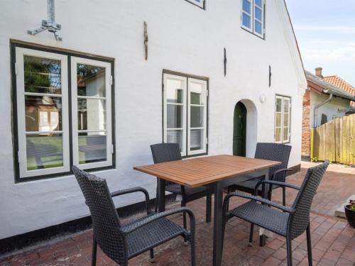 a patio with a wooden table and chairs at Holiday Home Odeta - 25km from the sea by Interhome in Højer