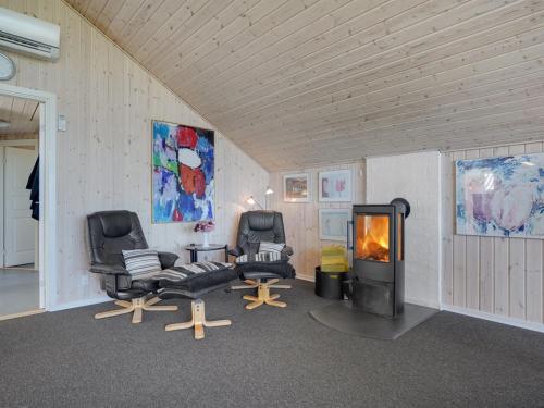 a living room with two chairs and a fireplace at Holiday Home Saila - 500m to the fjord by Interhome in Blåvand