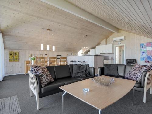 a living room with a couch and a table at Holiday Home Saila - 500m to the fjord by Interhome in Blåvand