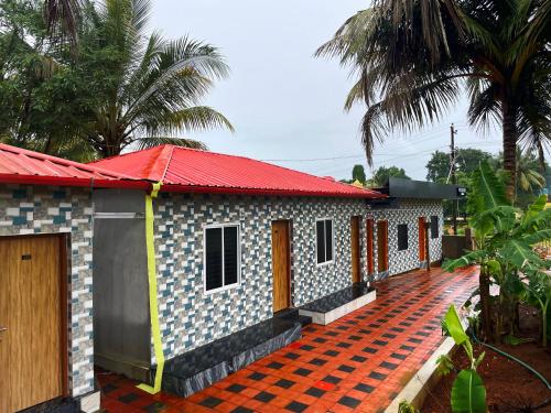 a small house with a red roof at Shri Ishwari home stay Murdeshwar in Māvalli