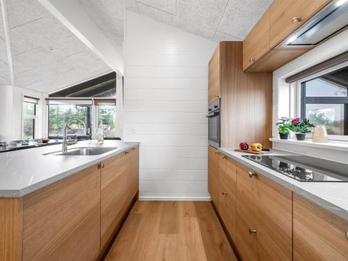 a kitchen with wooden cabinets and a sink at Holiday Home Elisenda - 625m from the sea by Interhome in Skagen