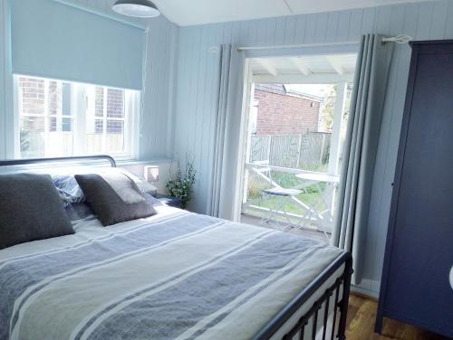 a bedroom with a bed and a large window at Hydaway in Bacton