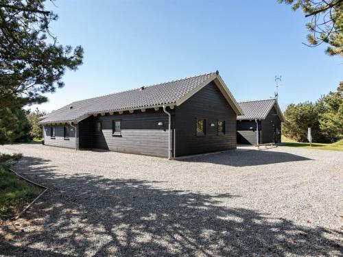a large black building with a garage at Holiday Home Lova - 600m from the sea by Interhome in Blåvand