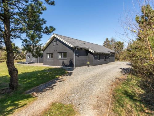 a barn with a gravel road in front of a house at Holiday Home Lova - 600m from the sea by Interhome in Blåvand