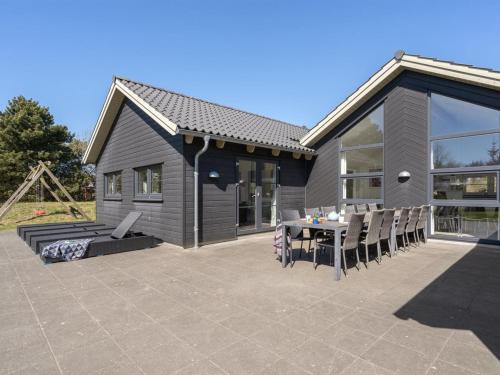 a house with a patio with a table and chairs at Holiday Home Lova - 600m from the sea by Interhome in Blåvand
