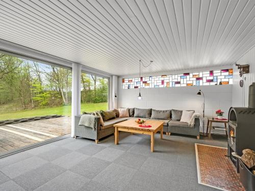 a living room with a couch and a table at Holiday Home Dwerg - 300m to the fjord by Interhome in Lihme