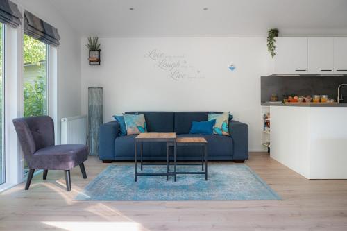 ヌンスペートにあるVlinder, verblijf in de bossenの青いソファとテーブルのあるリビングルーム