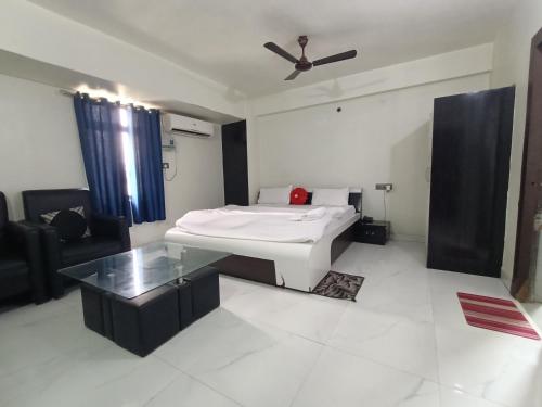 a living room with a bed and a glass table at Hotel Naman in Patna
