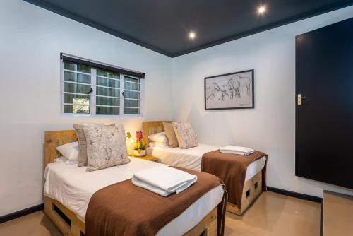 En eller flere senge i et værelse på Woodlands Cottage, Constantia