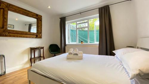 a bedroom with a bed with two shoes on it at Spacious 1 Bedroom near central London Kings Cross walking to Arnos Grove Tube, Alexandra Palace, Euston in New Southgate