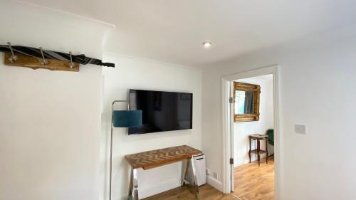 a room with a flat screen tv on a wall at Spacious 1 Bedroom near central London Kings Cross walking to Arnos Grove Tube, Alexandra Palace, Euston in New Southgate