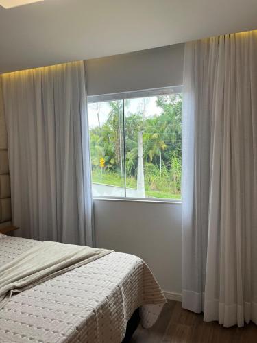 a bedroom with a bed and a window at Studio aconchegante e tranquilo! Perto de tudo! in Indaial