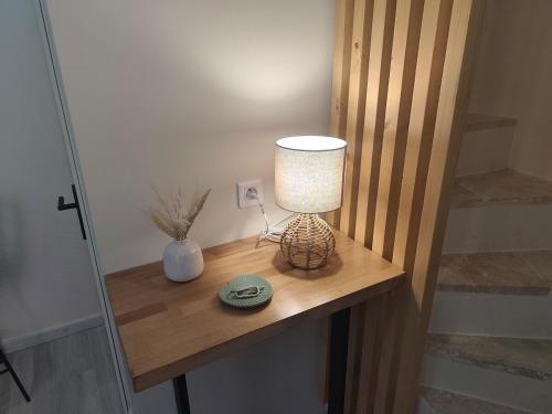 a lamp sitting on a wooden table in a room at Escapade dans le Luberon in Cavaillon