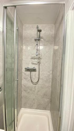 a shower with a glass door in a bathroom at Spacious 1 Bedroom near central London Kings Cross walking to Arnos Grove Tube, Alexandra Palace, Euston in New Southgate