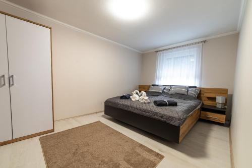 a bedroom with a large bed and a window at Napsugár & Virág Apartman in Tiszafüred