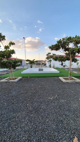 a park with two trees in the middle at شاليهات Chalets in Būbādī