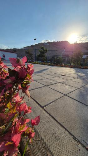a tennis court with the sun setting in the background at شاليهات Chalets in Būbādī