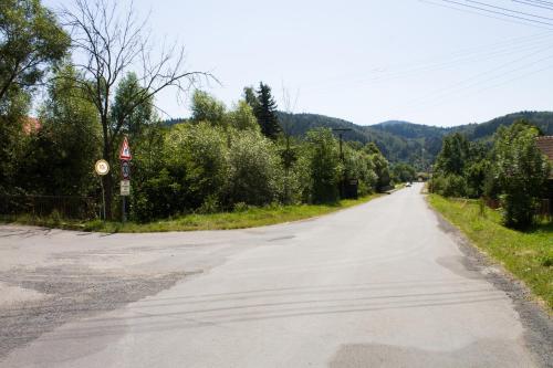 an empty road with trees on either side at Chalupa na Valašsku in Halenkov