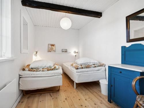 a bedroom with two beds and a blue cabinet at Holiday Home Héléne - 2-4km from the sea by Interhome in Åkirkeby