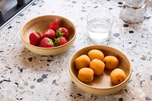 two bowls of strawberries and oranges and a bowl of fruit at Offgrid Cabin Klaudia am See in Brandenburg Tiny House Natururlaub & Retreat bei Berlin 