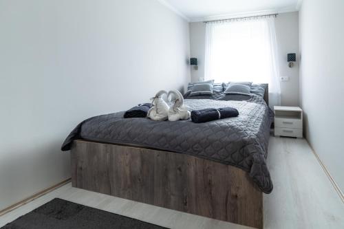a bedroom with a large bed with a wooden headboard at Napsugár & Virág Apartman in Tiszafüred