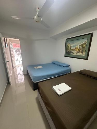 two beds in a small room with a window at Apartamento in Cartagena de Indias