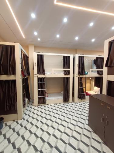 a room with multiple bunk beds with a checkered floor at Kashi V Homestay in Varanasi