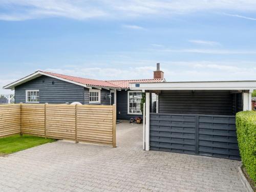 a house with a fence and a garage at Holiday Home Diddi - 170m from the sea by Interhome in Frørup