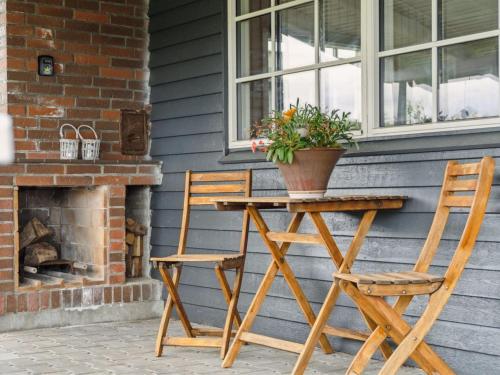 a table and two chairs with a potted plant on a porch at Holiday Home Diddi - 170m from the sea by Interhome in Frørup