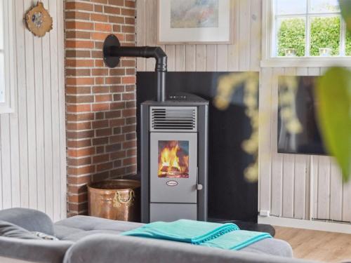 a fireplace in a living room with a stove at Holiday Home Diddi - 170m from the sea by Interhome in Frørup