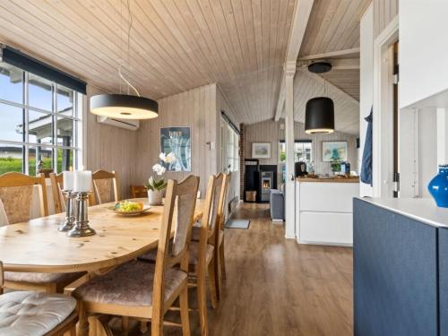 a kitchen and dining room with a wooden table and chairs at Holiday Home Diddi - 170m from the sea by Interhome in Frørup
