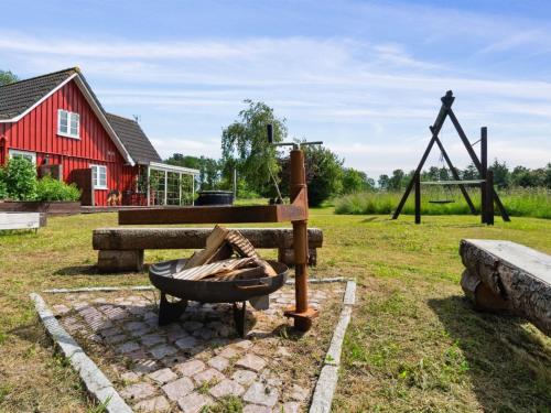 a playground with a red barn and a swing at Holiday Home Ieva - 3-9km from the sea by Interhome in Åkirkeby