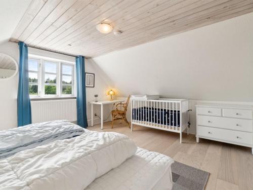 a bedroom with a bed and a crib and a desk at Holiday Home Ieva - 3-9km from the sea by Interhome in Åkirkeby