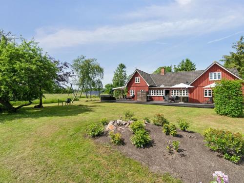 a red house with a garden in front of it at Holiday Home Ieva - 3-9km from the sea by Interhome in Åkirkeby