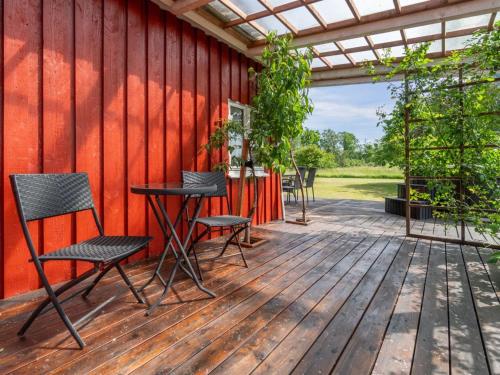 a patio with chairs and a table on a wooden deck at Holiday Home Ieva - 3-9km from the sea by Interhome in Åkirkeby