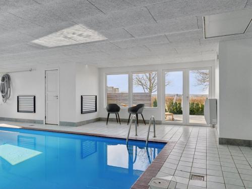 a living room with a swimming pool and two chairs at Holiday Home Neele - 800m from the sea by Interhome in Glesborg