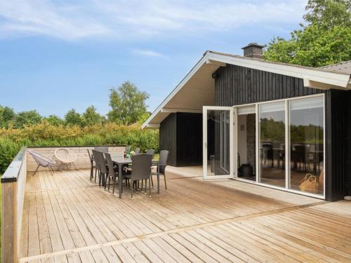 a wooden deck with a table and chairs on it at Holiday Home Neele - 800m from the sea by Interhome in Glesborg