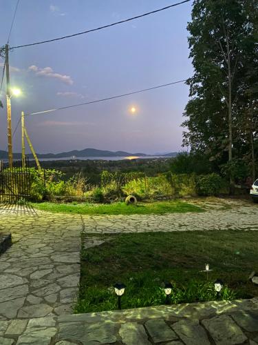 a stone patio with the moon in the sky at To σαλέ της λίμνης 2 in Kalyvia Fylaktis
