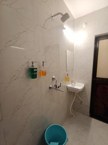 a bathroom with a shower with a sink and a toilet at Kashi V Homestay in Varanasi