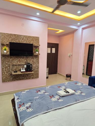 a room with a bed and a tv on a wall at Kashi V Homestay in Varanasi