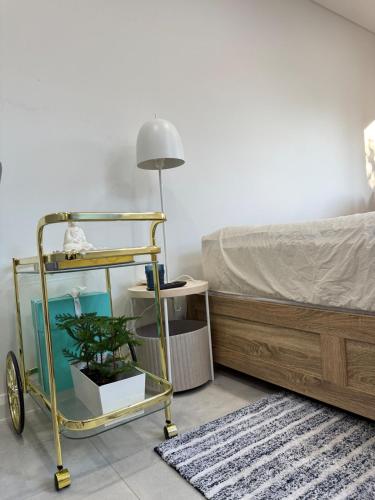 a bedroom with a bed and a plant on a cart at Fully equipped brand new built studio in Chipping Norton