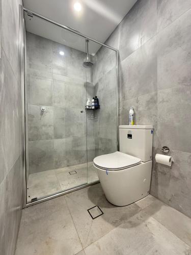 a bathroom with a toilet and a glass shower at Fully equipped brand new built studio in Chipping Norton