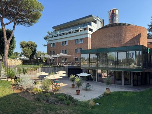 a building with tables and umbrellas in front of it at Adoro Hotel in Rome